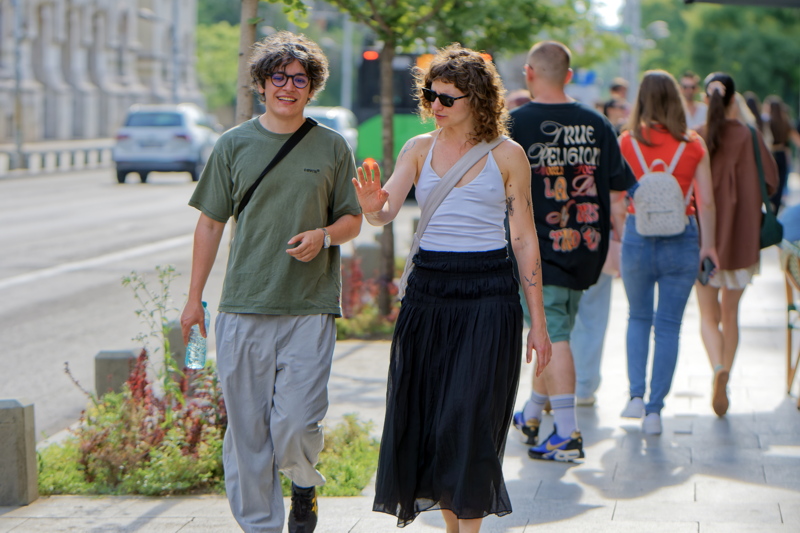 24 - Couple walking on a sidewalk